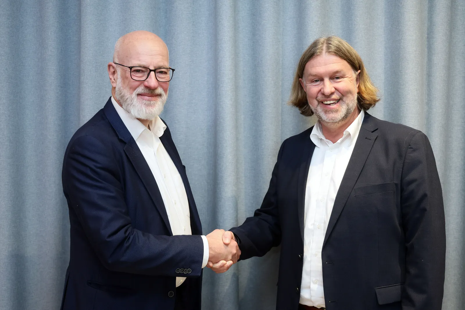 Verbandsvorsteher Ingo Schabrich (links), Ludger Hendriks (rechts) Verbandsvorsteher Ingo Schabrich (links), Ludger Hendriks (rechts) stehen vor einem Vorhang und reichen sich die Hände